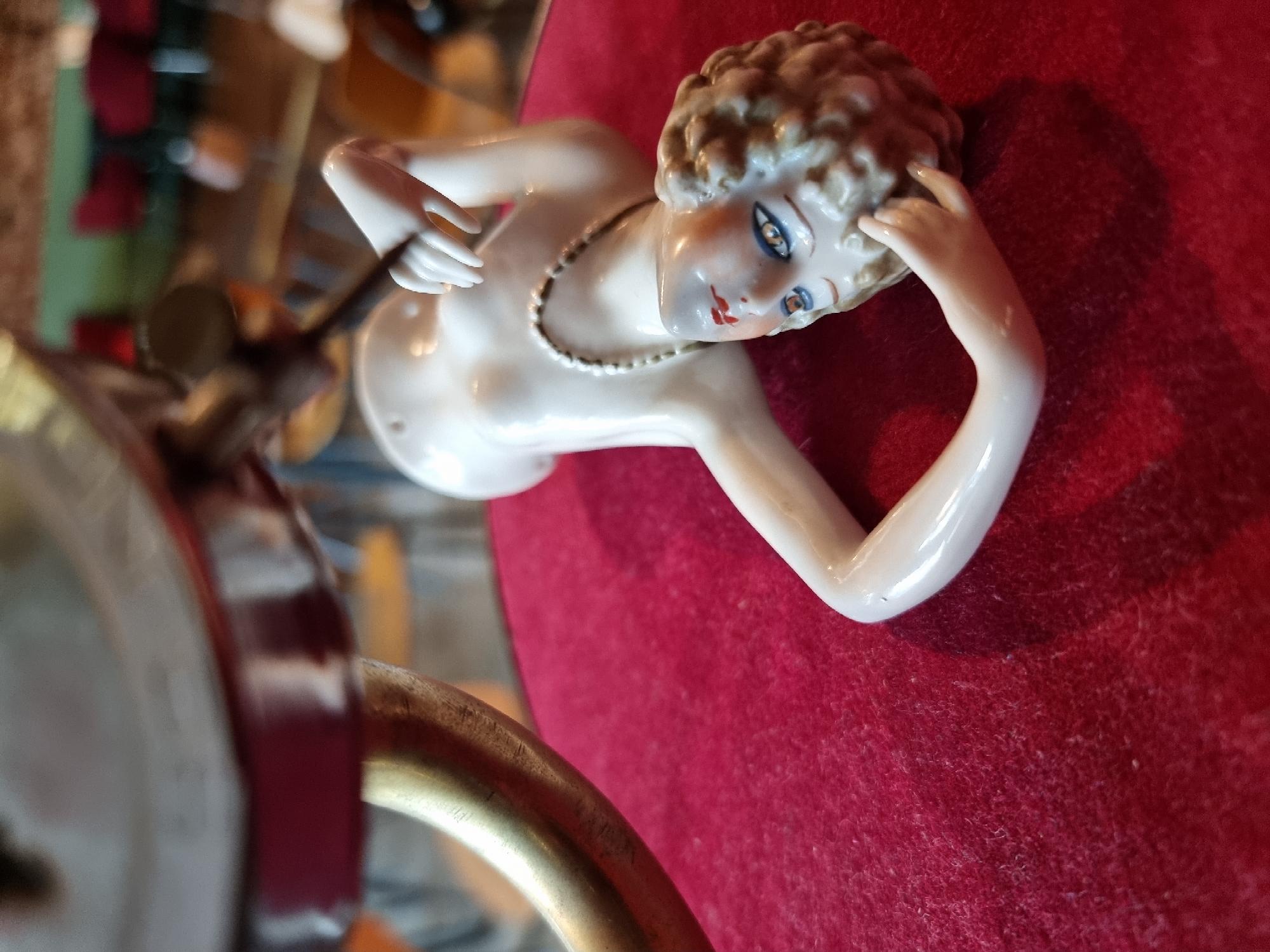 Porcelain figurine lying on red fabric